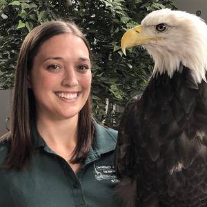 Dr. Victoria Hall posing with a bald eagle